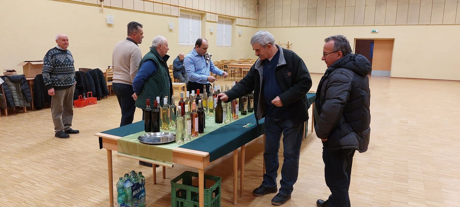 Vinári ochutnávajú a debatujú pri stole s mladými vínami